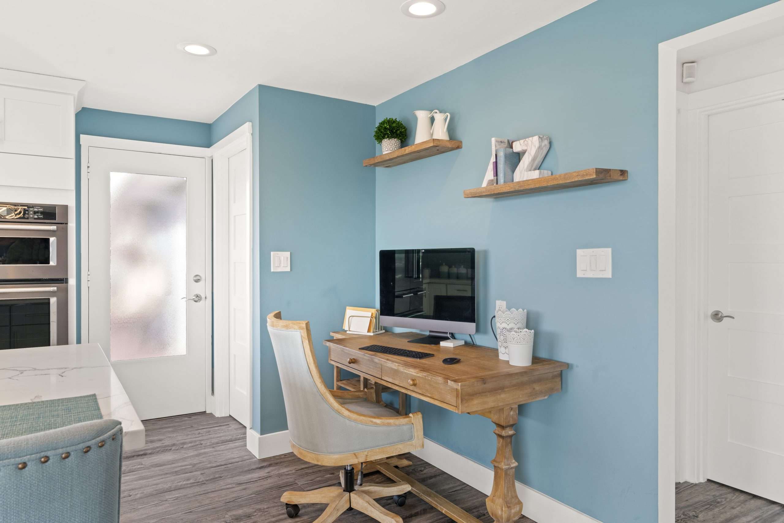 Picture of a kitchen with a desk neatly in one corner